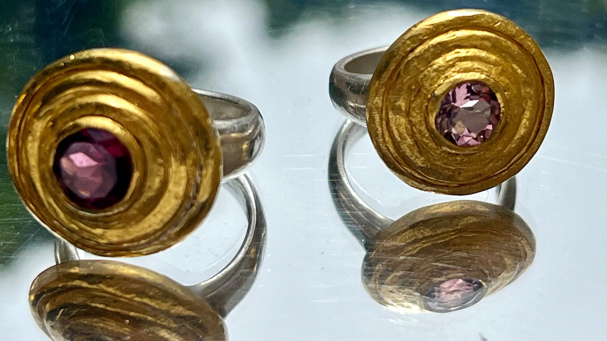 Two gold step rings on glass